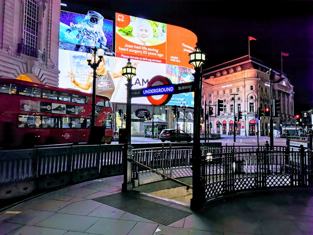 Vibrant night scene of Piccadilly Circus with iconic London landmarks and lights.